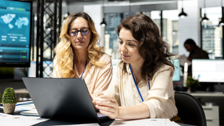dos mujeres del sector seguros trabajando frente a un ordenador con un software asegurador